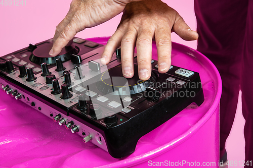 Image of Senior hipster man wearing eyeglasses posing on pink background. Tech and joyful elderly lifestyle concept