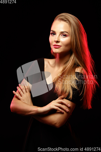 Image of Caucasian woman\'s portrait isolated on dark studio background in neon light