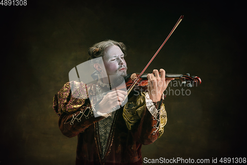 Image of Young man as Johann Sebastian Bach on dark green background. Retro style, comparison of eras concept.