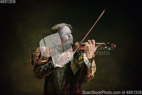 Image of Young man as Johann Sebastian Bach on dark green background. Retro style, comparison of eras concept.