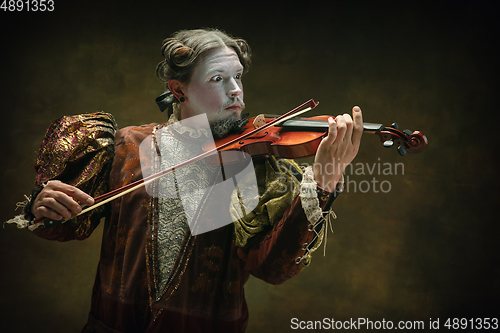 Image of Young man as Johann Sebastian Bach on dark green background. Retro style, comparison of eras concept.