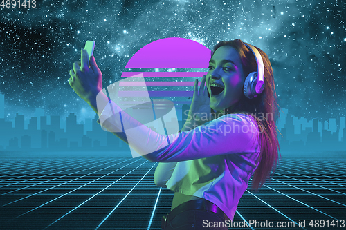 Image of Synth wave and retro wave, vaporwave futuristic aesthetics. Woman with device in glowing neon style.