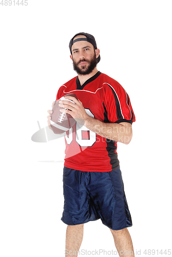 Image of Young football player standing with his football in his hand