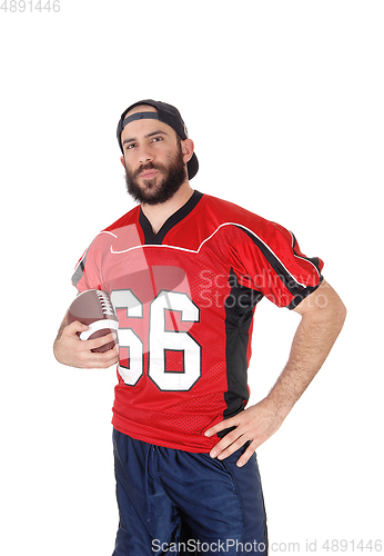 Image of Young football player standing in closeup with his football 