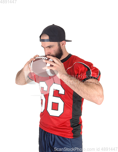 Image of Football player holding his ball on his mouth thinking