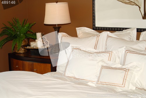 Image of Bed with white bedspread and nightstand