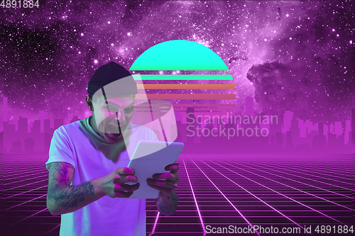 Image of Synth wave and retro wave, vaporwave futuristic aesthetics. Man with device in glowing neon style.