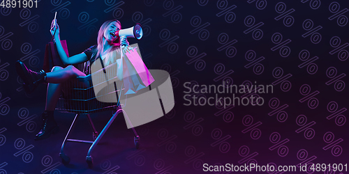 Image of Portrait of young woman in neon light on dark backgound. The human emotions, black friday, cyber monday, purchases, sales, finance concept. Neoned lettering.