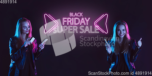 Image of Portrait of young woman in neon light on dark backgound. The human emotions, black friday, cyber monday, purchases, sales, finance concept. Neoned lettering.