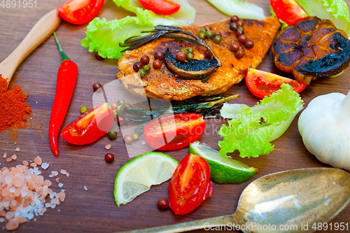 Image of wood fired hoven cooked chicken breast on wood board