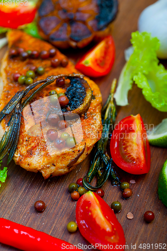 Image of wood fired hoven cooked chicken breast on wood board