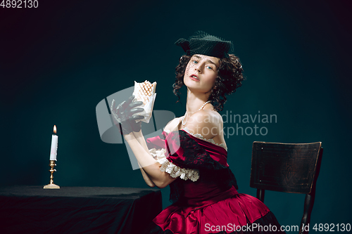 Image of Young woman as Anna Karenina on dark blue background. Retro style, comparison of eras concept.