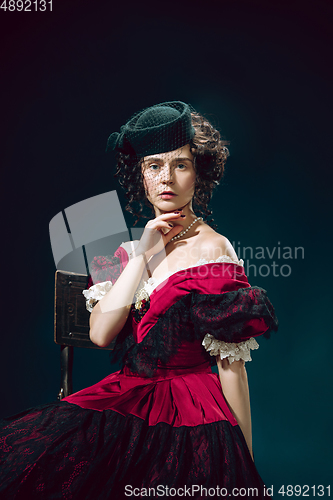 Image of Young woman as Anna Karenina on dark blue background. Retro style, comparison of eras concept.