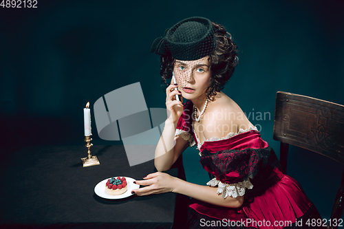 Image of Young woman as Anna Karenina on dark blue background. Retro style, comparison of eras concept.