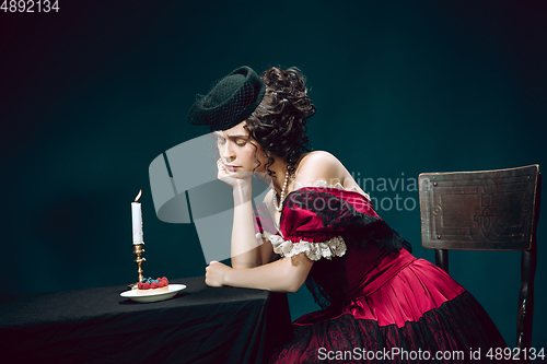 Image of Young woman as Anna Karenina on dark blue background. Retro style, comparison of eras concept.