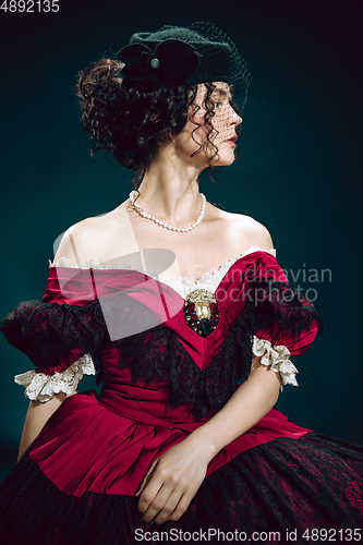 Image of Young woman as Anna Karenina on dark blue background. Retro style, comparison of eras concept.