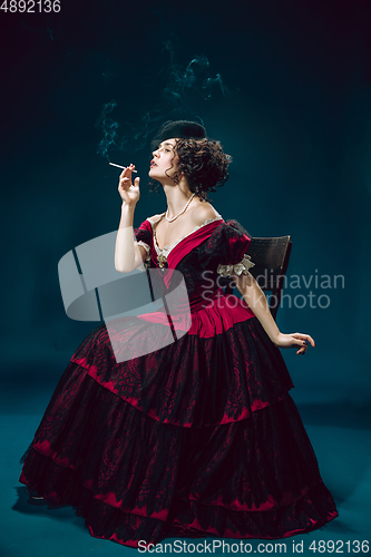 Image of Young woman as Anna Karenina on dark blue background. Retro style, comparison of eras concept.