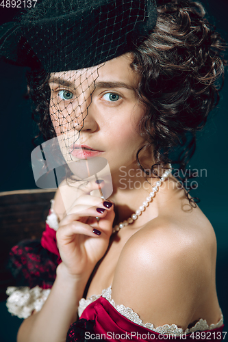 Image of Young woman as Anna Karenina on dark blue background. Retro style, comparison of eras concept.