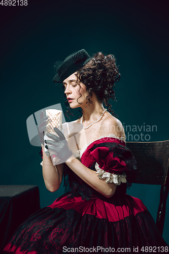 Image of Young woman as Anna Karenina on dark blue background. Retro style, comparison of eras concept.