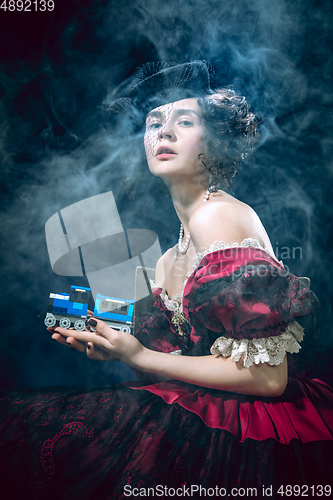 Image of Young woman as Anna Karenina on dark blue background. Retro style, comparison of eras concept.