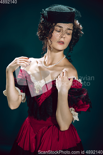 Image of Young woman as Anna Karenina on dark blue background. Retro style, comparison of eras concept.