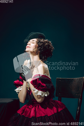 Image of Young woman as Anna Karenina on dark blue background. Retro style, comparison of eras concept.