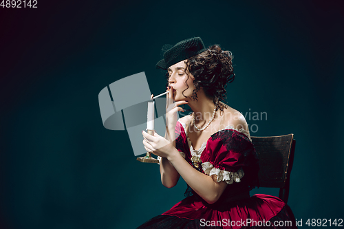 Image of Young woman as Anna Karenina on dark blue background. Retro style, comparison of eras concept.