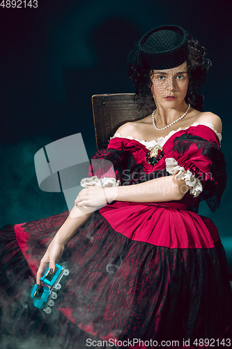 Image of Young woman as Anna Karenina on dark blue background. Retro style, comparison of eras concept.