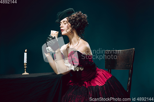 Image of Young woman as Anna Karenina on dark blue background. Retro style, comparison of eras concept.