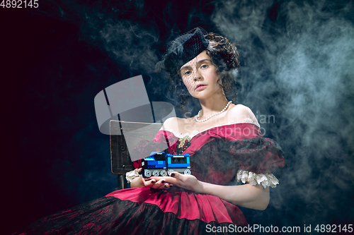 Image of Young woman as Anna Karenina on dark blue background. Retro style, comparison of eras concept.