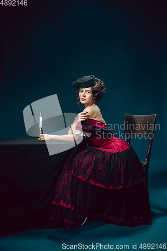 Image of Young woman as Anna Karenina on dark blue background. Retro style, comparison of eras concept.