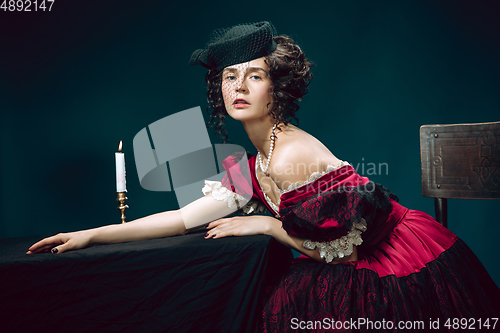 Image of Young woman as Anna Karenina on dark blue background. Retro style, comparison of eras concept.