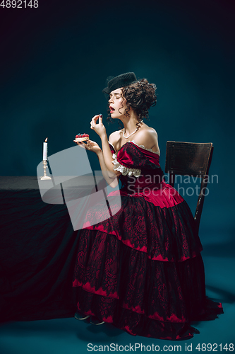 Image of Young woman as Anna Karenina on dark blue background. Retro style, comparison of eras concept.