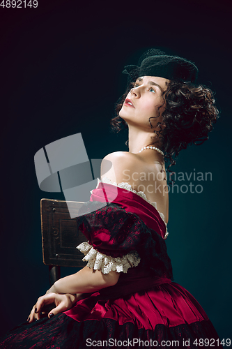 Image of Young woman as Anna Karenina on dark blue background. Retro style, comparison of eras concept.