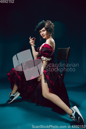 Image of Young woman as Anna Karenina on dark blue background. Retro style, comparison of eras concept.