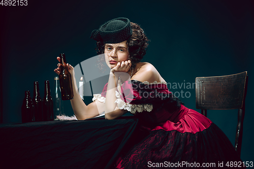 Image of Young woman as Anna Karenina on dark blue background. Retro style, comparison of eras concept.