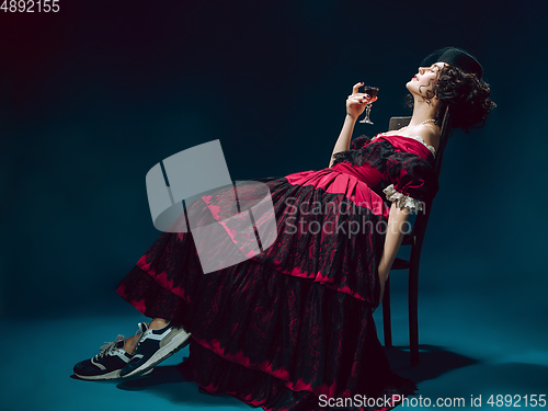 Image of Young woman as Anna Karenina on dark blue background. Retro style, comparison of eras concept.