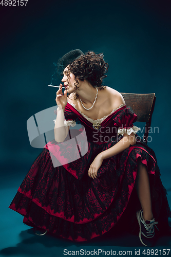 Image of Young woman as Anna Karenina on dark blue background. Retro style, comparison of eras concept.