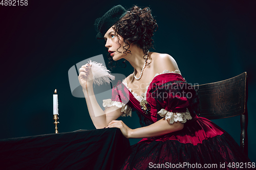 Image of Young woman as Anna Karenina on dark blue background. Retro style, comparison of eras concept.