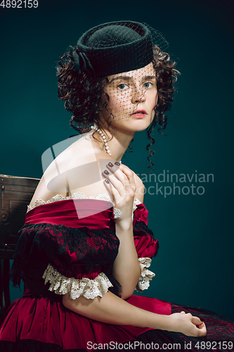 Image of Young woman as Anna Karenina on dark blue background. Retro style, comparison of eras concept.