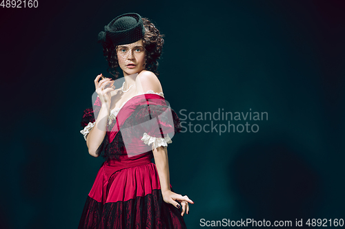 Image of Young woman as Anna Karenina on dark blue background. Retro style, comparison of eras concept.