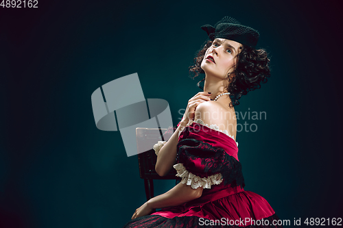 Image of Young woman as Anna Karenina on dark blue background. Retro style, comparison of eras concept.