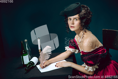 Image of Young woman as Anna Karenina on dark blue background. Retro style, comparison of eras concept.
