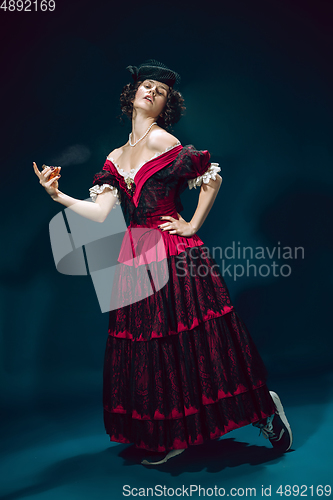 Image of Young woman as Anna Karenina on dark blue background. Retro style, comparison of eras concept.