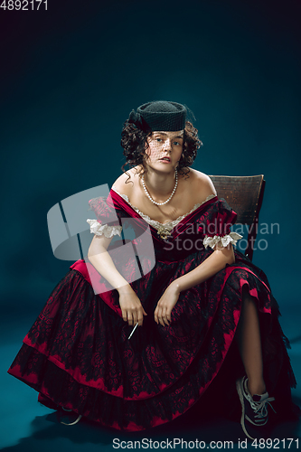 Image of Young woman as Anna Karenina on dark blue background. Retro style, comparison of eras concept.