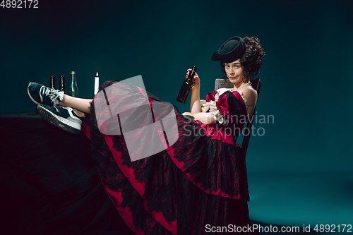 Image of Young woman as Anna Karenina on dark blue background. Retro style, comparison of eras concept.