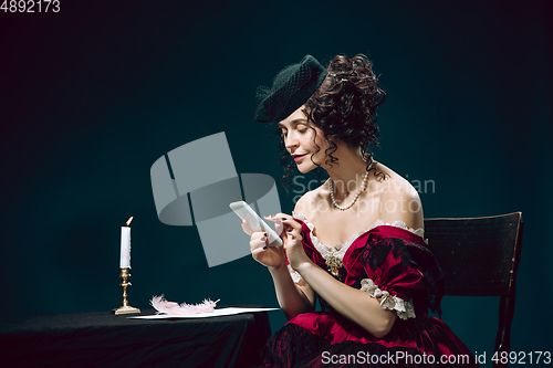 Image of Young woman as Anna Karenina on dark blue background. Retro style, comparison of eras concept.