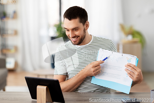 Image of man with tablet pc having video call at home