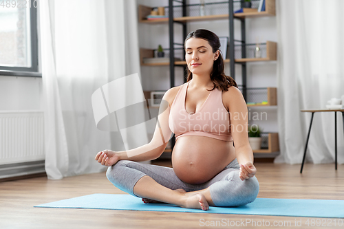 Image of pregnant woman meditating at home