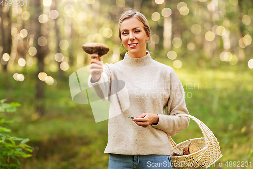 Image of young woman with mushroom in autumn forest